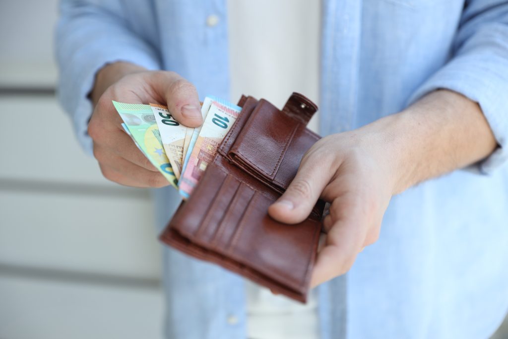 Persoon haalt eurobiljetten uit een portemonnee als beeld bij versneld aflossen op een lening