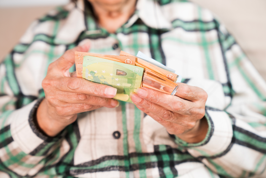 Oudere persoon telt eurobiljetten bij geld lenen na je 60e