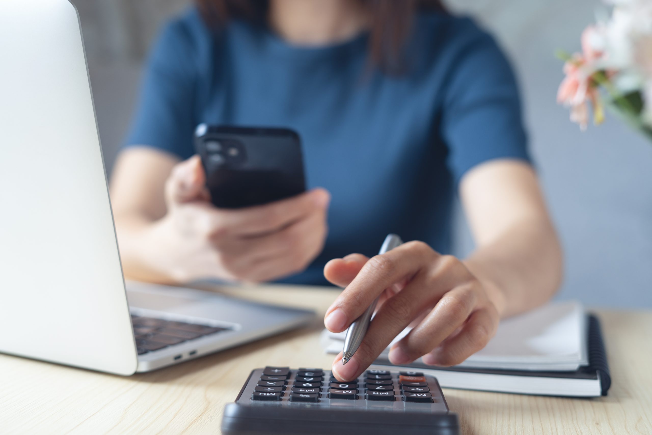 Vrouw berekent haar maximale lening met een laptop en rekenmachine
