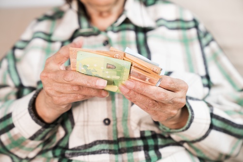 Persoon telt een stapel eurobiljetten met beide handen